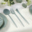 Aqua cutlery set including spoon, fork, and knife on a table setting.
