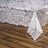 Clear lace table cover with elegant floral pattern draping over a wooden surface. #whtbkgd