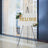 Welcome sign on an easel decorated with flowers in a stylish indoor setting.