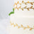 Elegant two-tiered wedding cake adorned with golden leaf details.