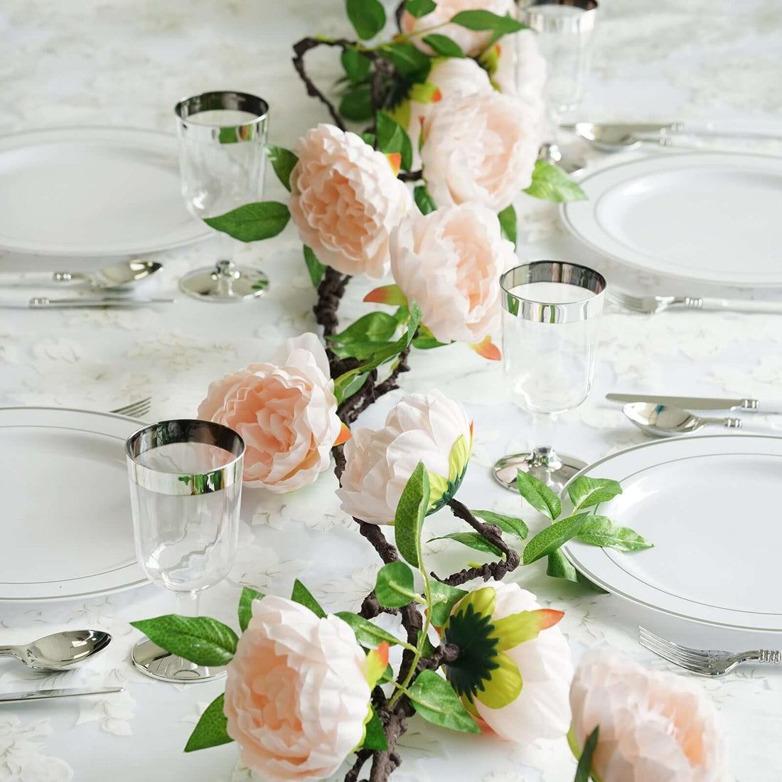 Table setting with pink flowers and glassware for an elegant dining experience.