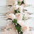 Elegant table setting with white plates, glassware, and pink roses.
