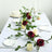 Elegant table setting with roses, candles, and dinnerware for a special occasion.