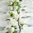 Elegant table setting with white flowers, plates, and glassware.