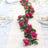 Artificial pink rose garland on a dining table setting.