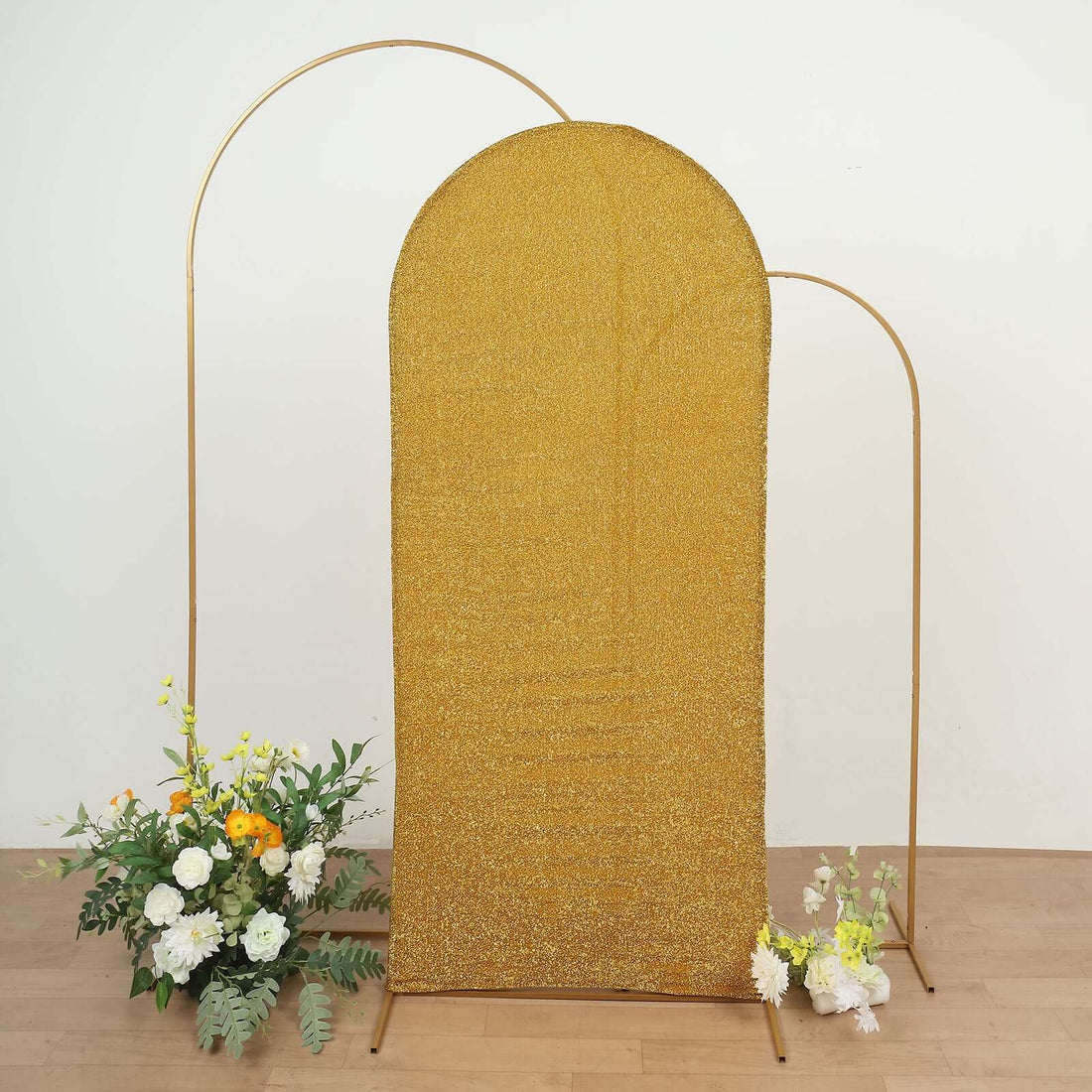 Gold sequined backdrop with metal frame and floral arrangements.