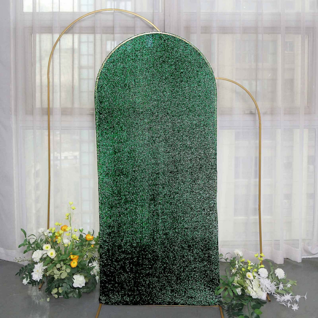 Green glitter backdrop with floral arrangements, perfect for events and photography.