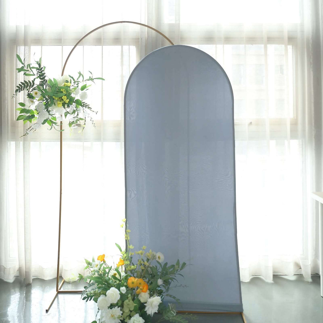 Decorative fabric backdrop with gold frame and floral arrangement