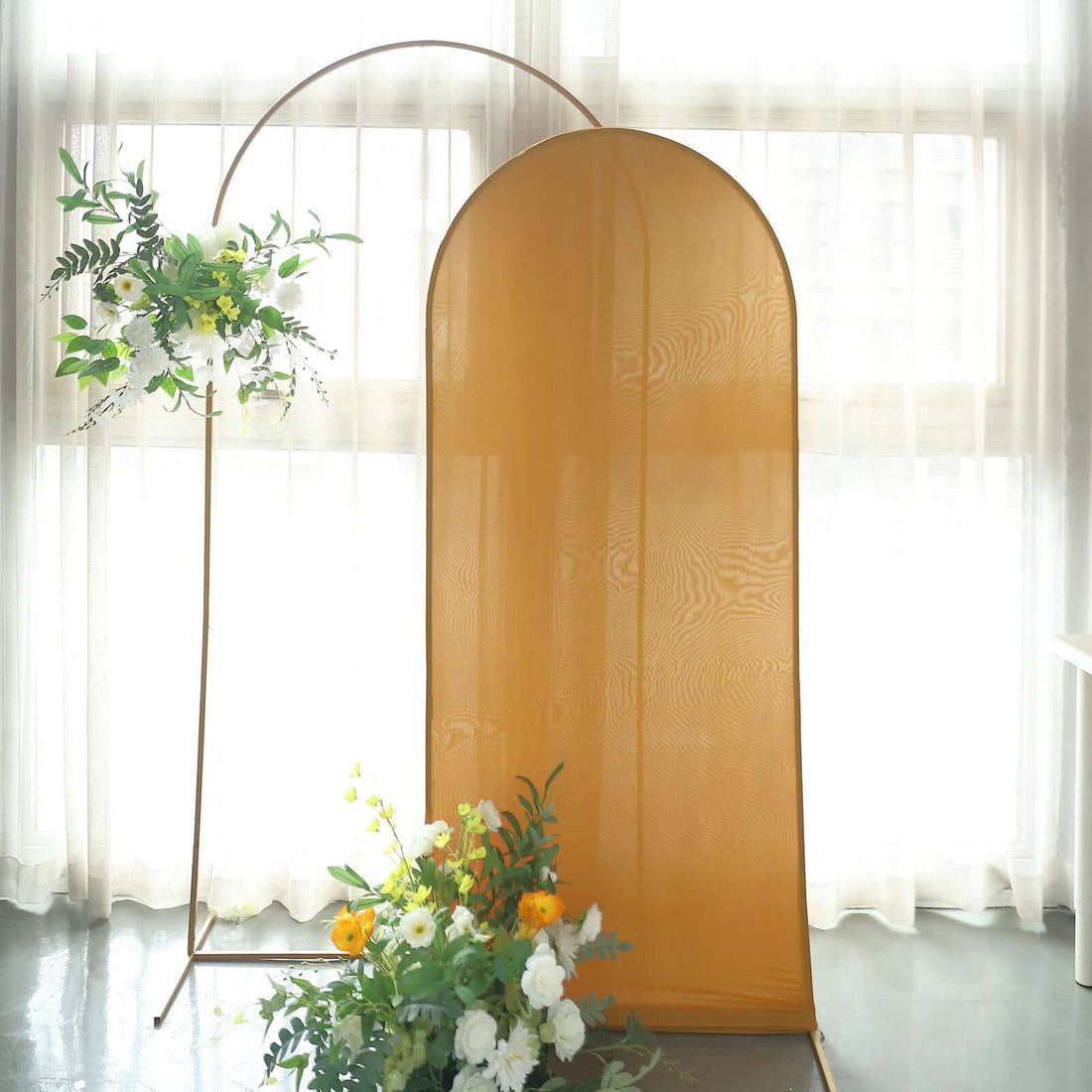 Decorative fabric backdrop with floral arrangement in a bright interior setting.