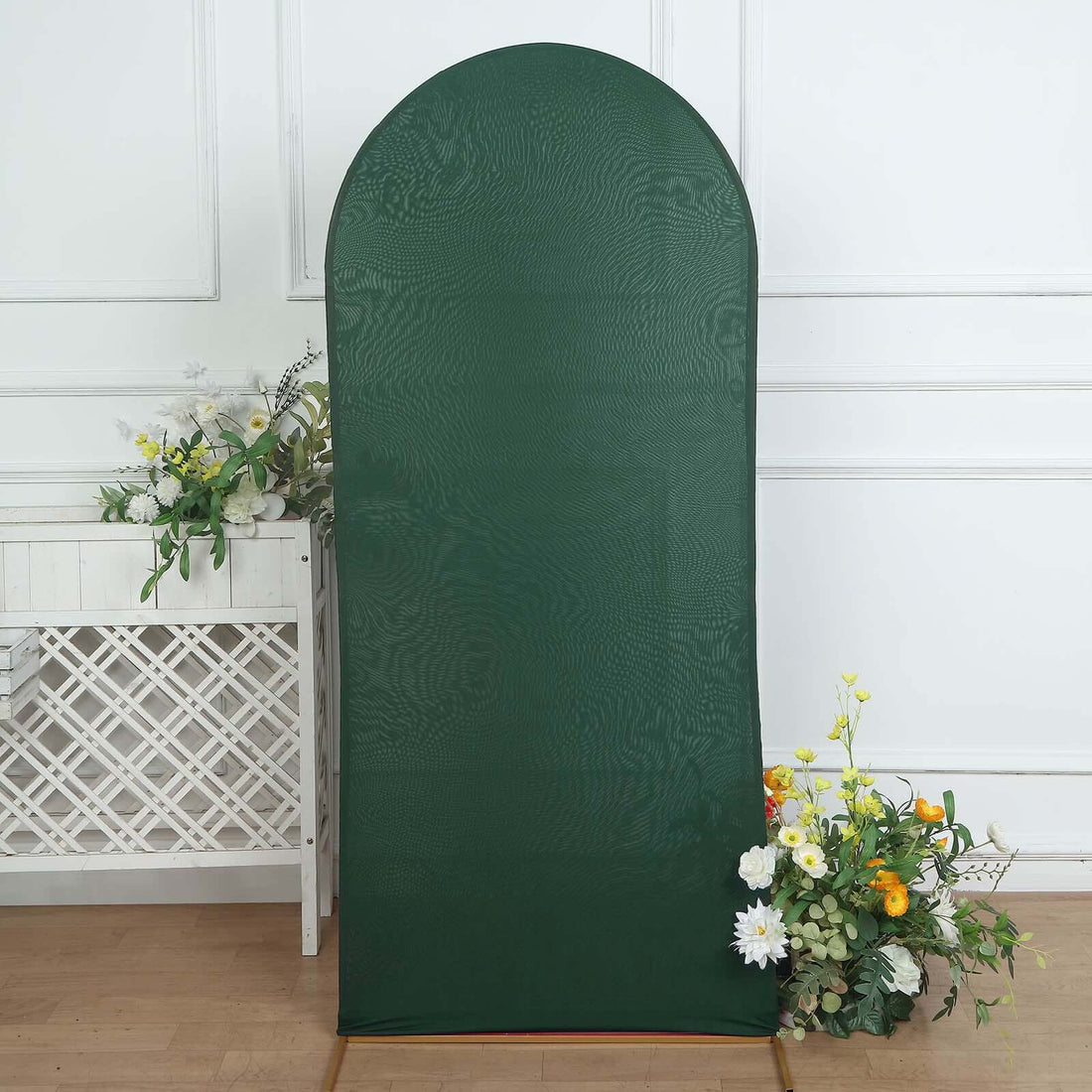 Green arch backdrop with floral arrangement, perfect for events or photography.