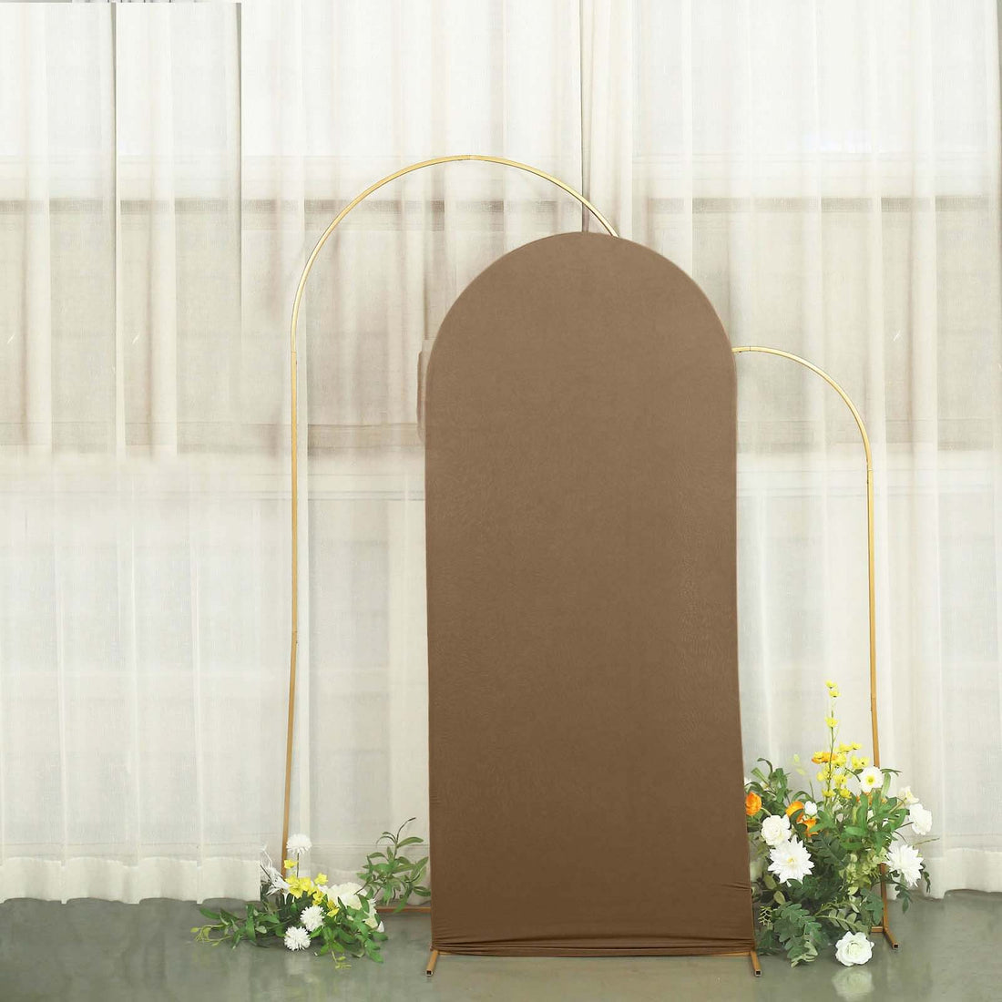 Brown curved backdrop with gold stand and floral accents.