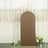 Brown curved backdrop with gold stand and floral accents.