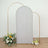 Silver glitter photo backdrop with gold arch and floral arrangement.