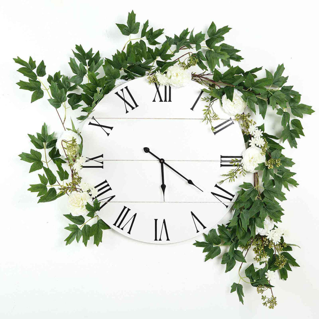 Wall clock adorned with greenery and white flowers