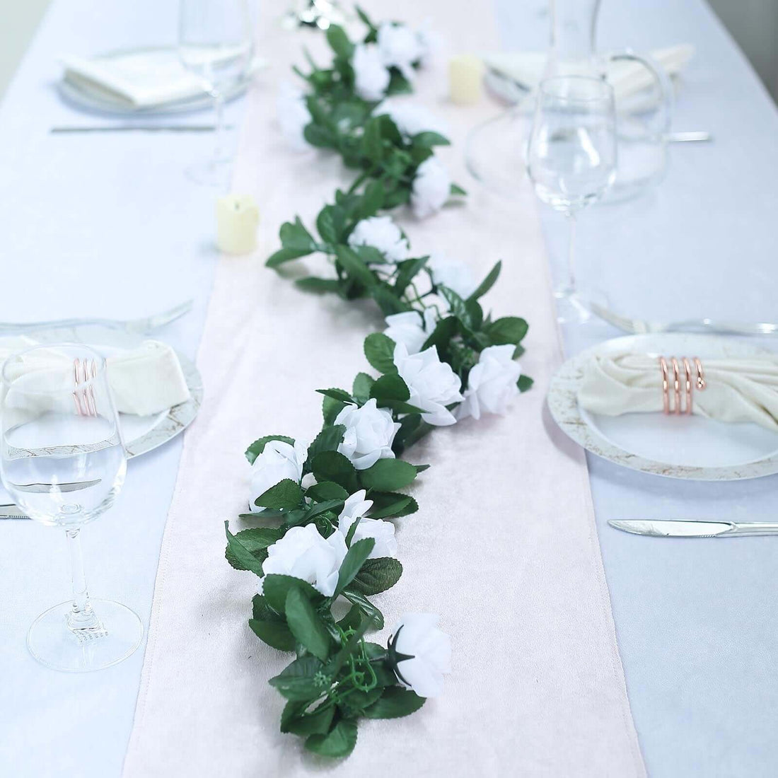 White floral table runner on an elegantly set dining table.