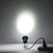 Black spotlight illuminating a white wall, plugged into a power strip. #whtbkgd