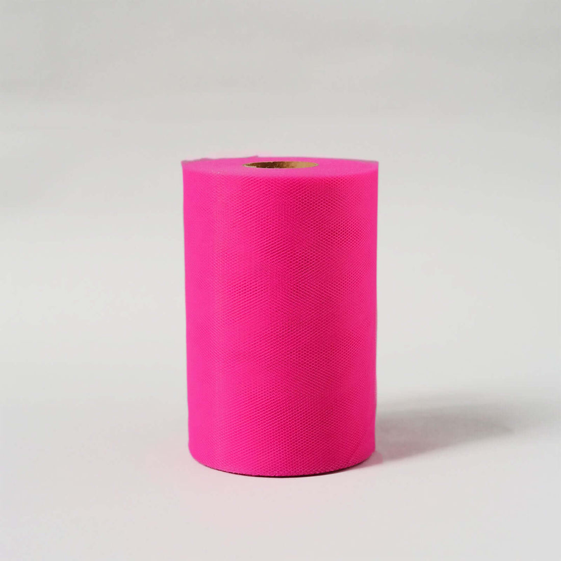 Bright pink roll of craft paper on a plain backdrop