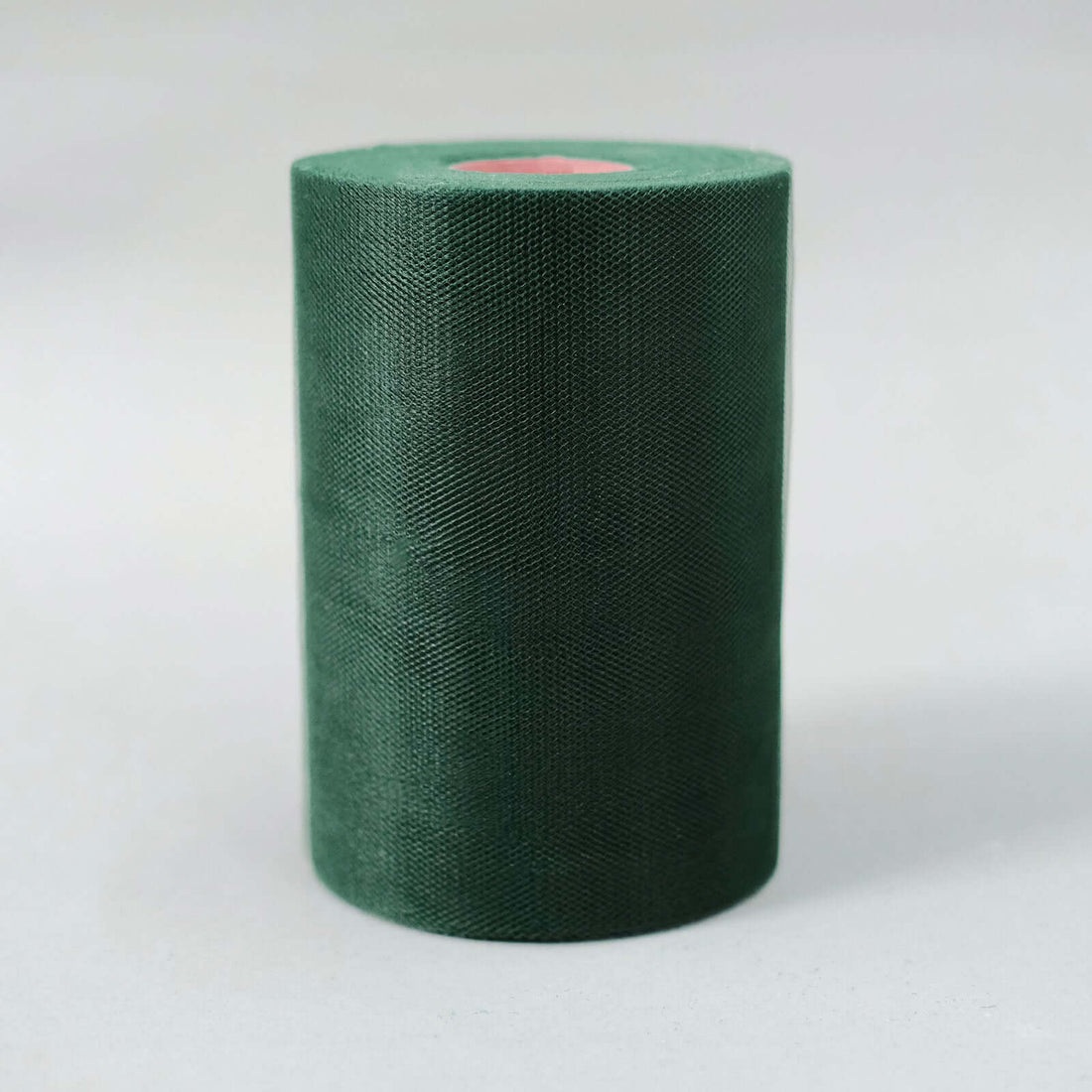 Green fabric roll on a plain background
