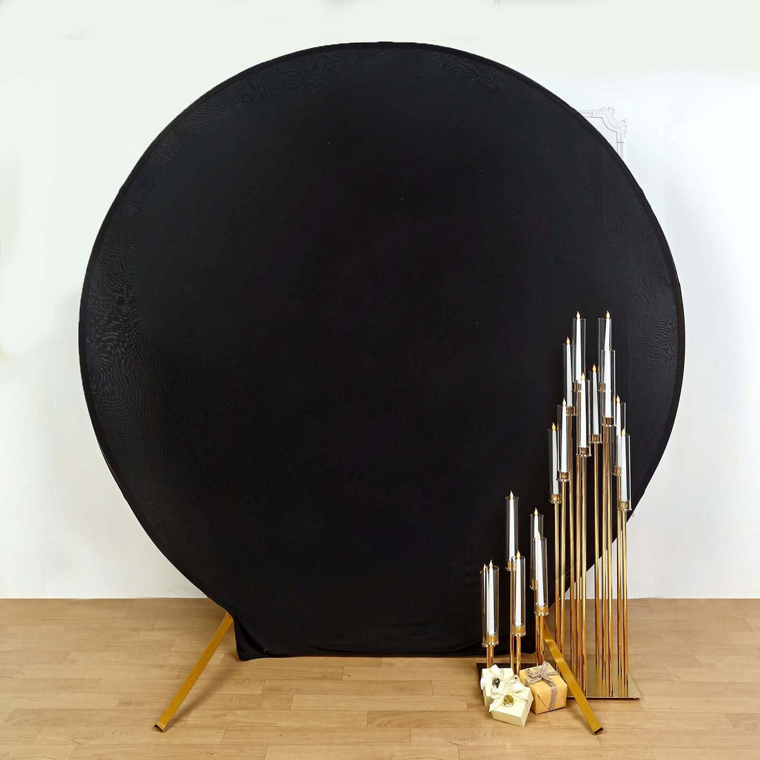 Gold candle holders arranged beside a black backdrop, showcasing elegant design.