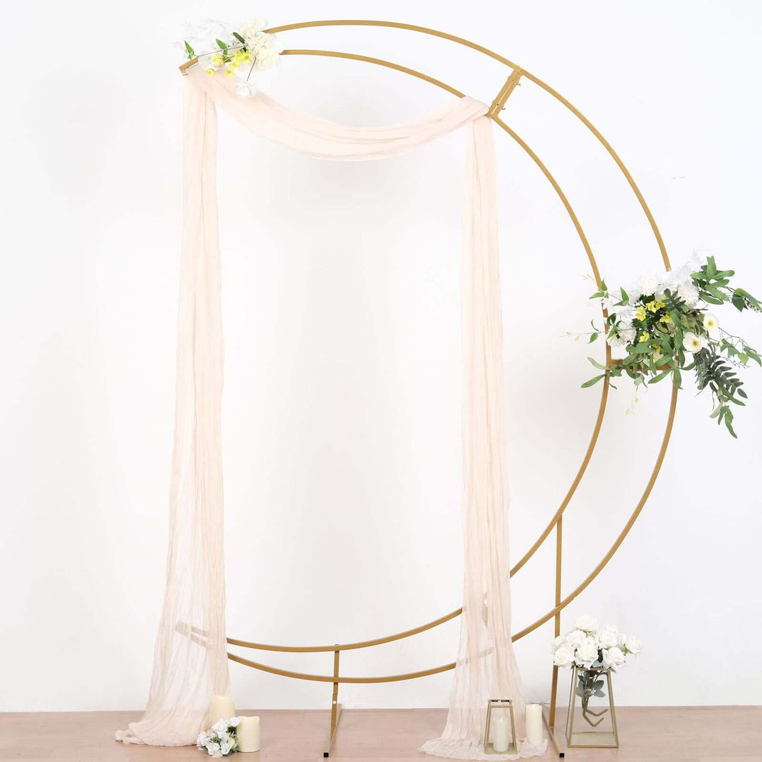 Gold wedding arch with draped fabric and floral accents