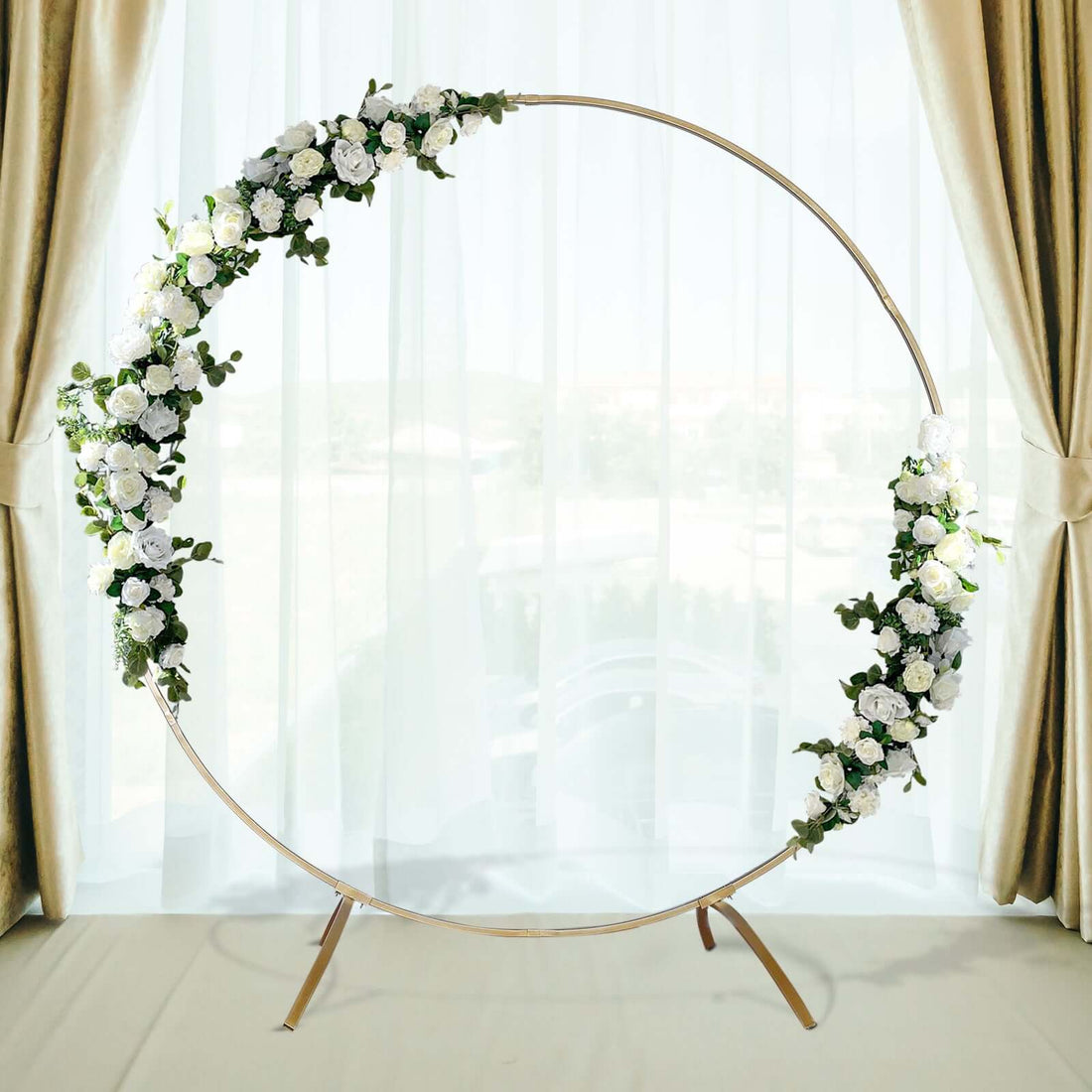 Floral wedding arch with white flowers on a circular frame.