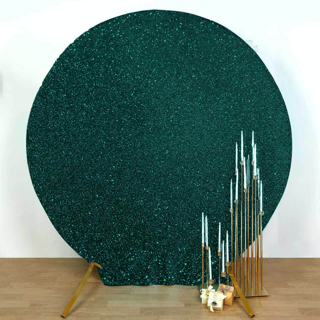 Teal glitter backdrop with gold candle holders and white candles.