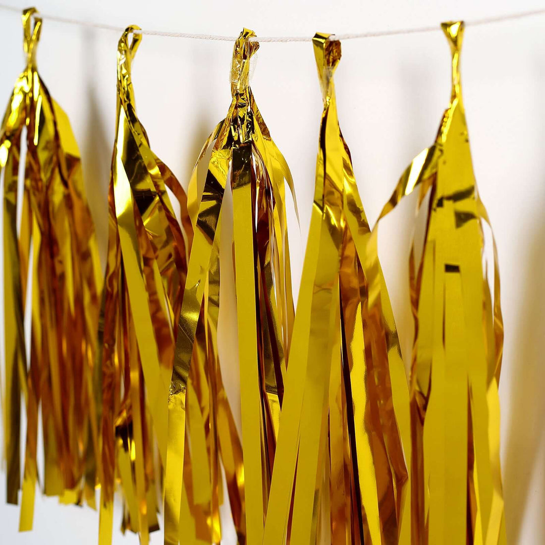 Gold foil party decorations hanging in a row.