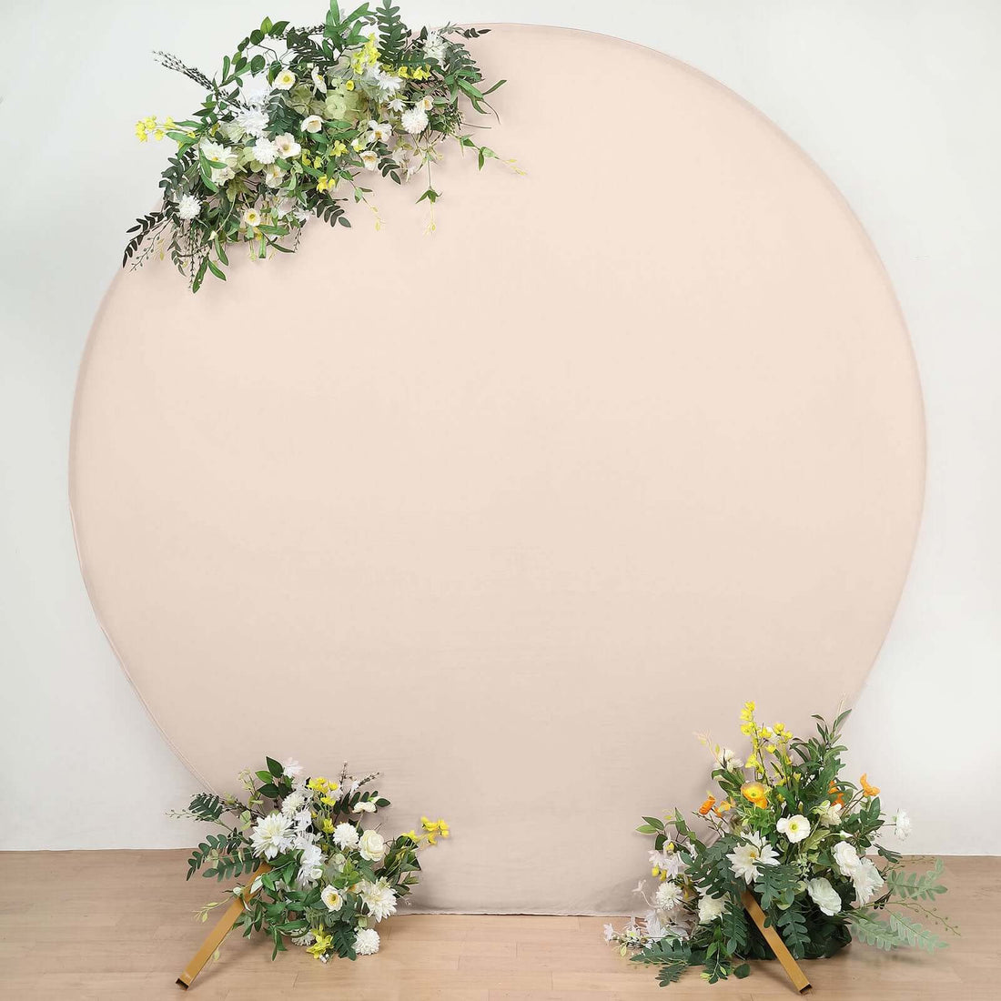 Floral arrangement on a round backdrop with greenery and blooms.