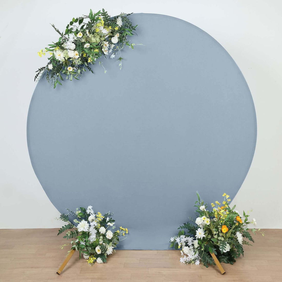 Decorative round backdrop with floral arrangements on a wooden floor.