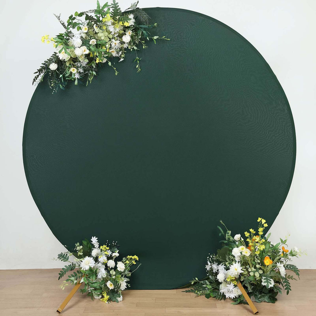 Green circular backdrop with floral arrangements for photography.