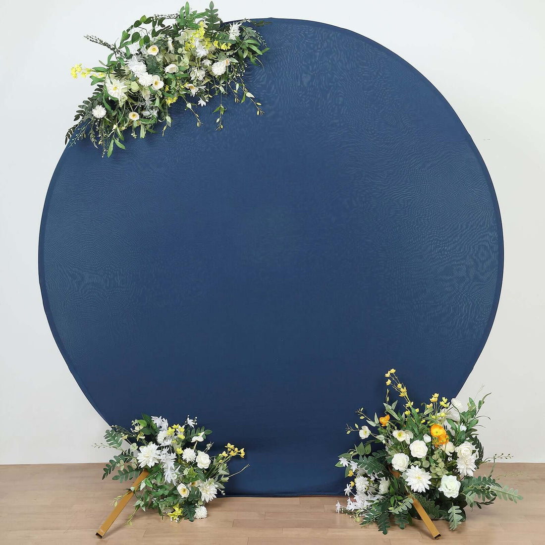Navy blue circle backdrop with floral arrangements on both sides.