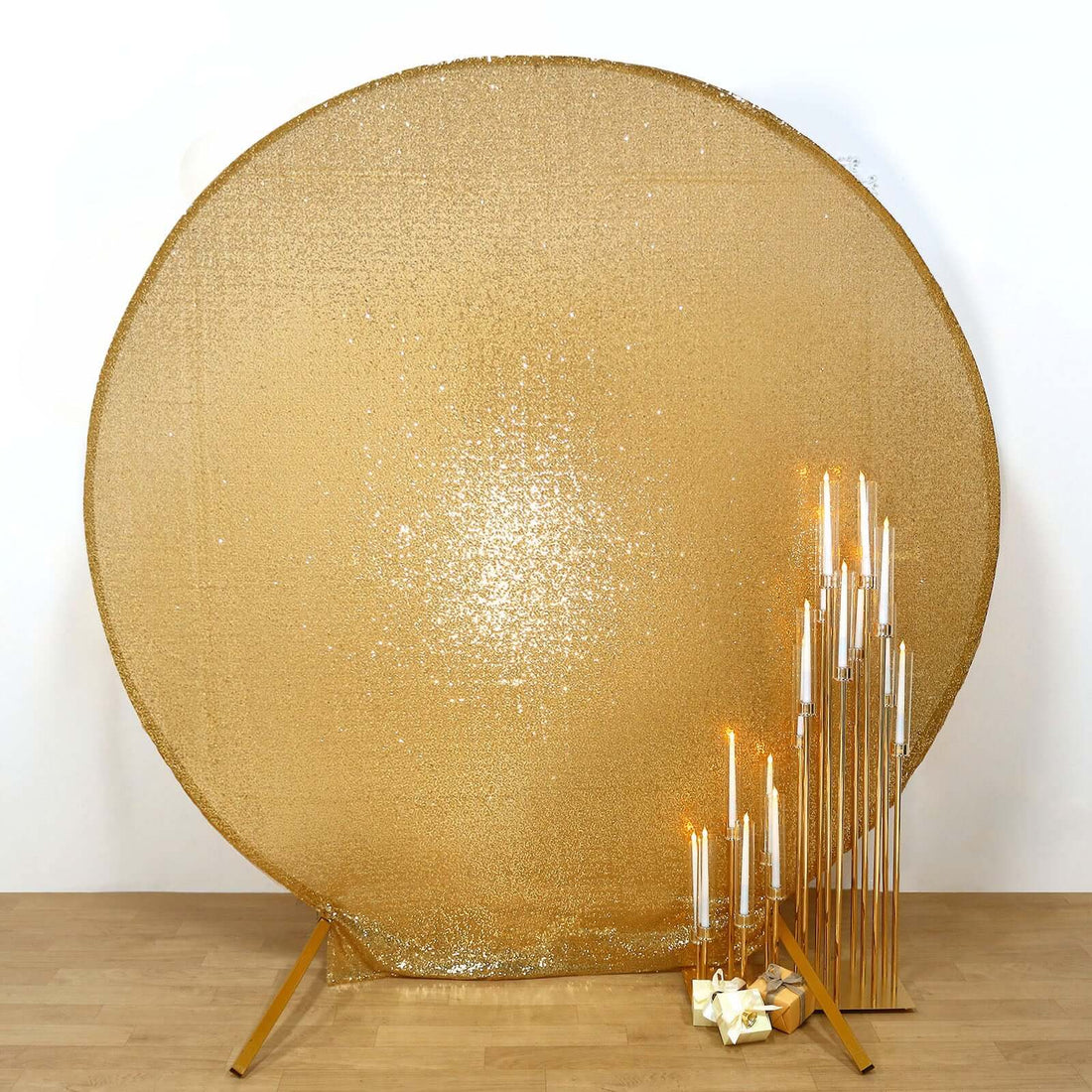 Gold sequin backdrop with decorative candle holders for events and photo shoots.