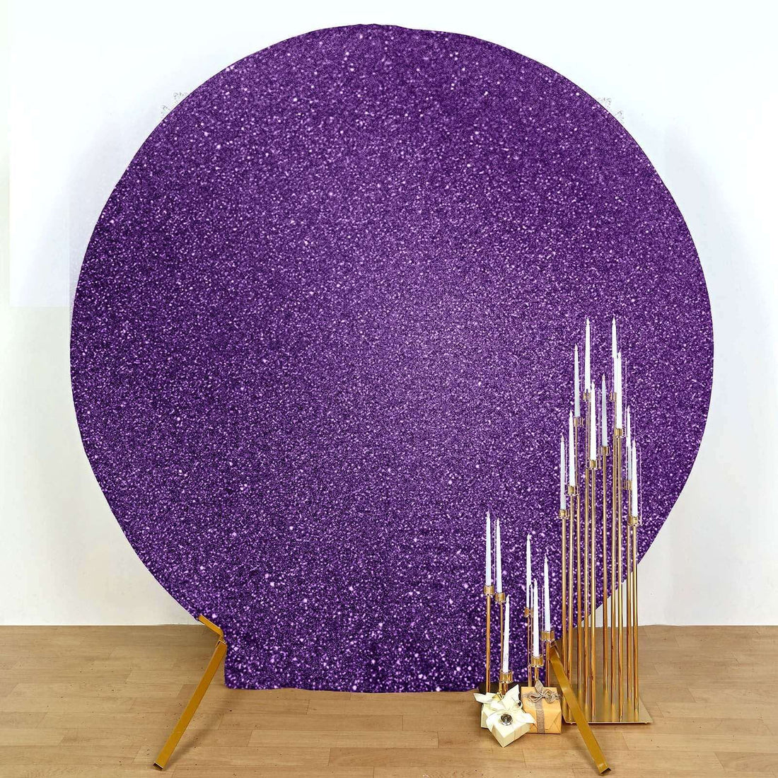 Purple glitter backdrop with gold candle holders.