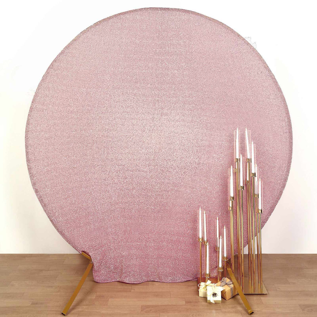 Pink glitter backdrop with decorative gold candle holders and candles.