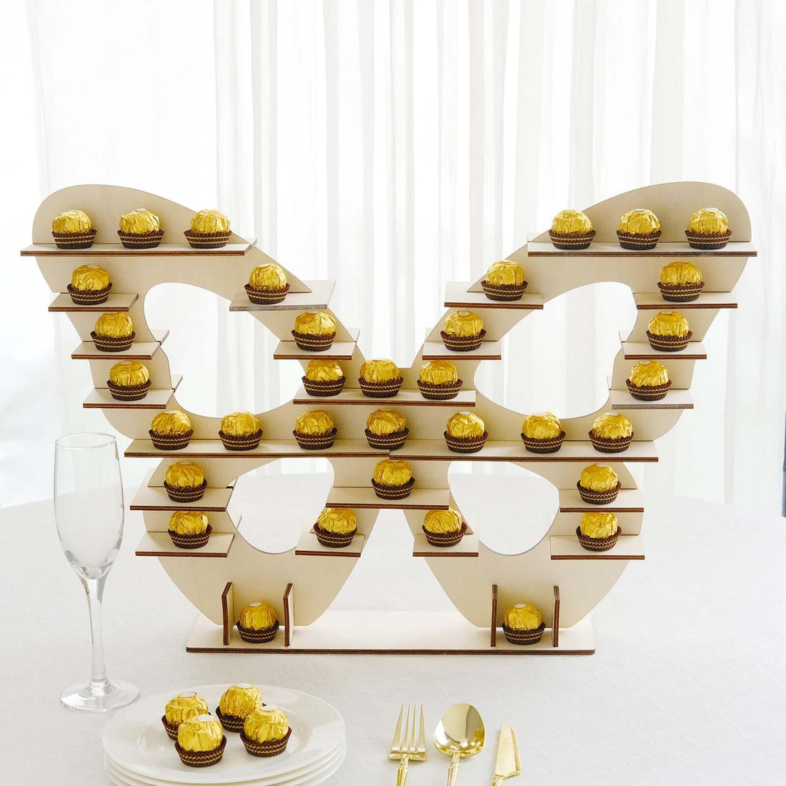 Butterfly-shaped cupcake display with golden cupcakes on tiers.