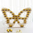 Butterfly-shaped cupcake display with golden cupcakes on tiers.