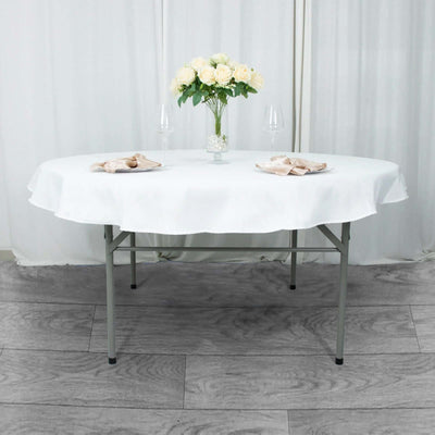 Round folding table set for dining with flowers and glasses.