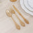 Elegant gold plastic cutlery set on a wooden table.