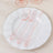 Pink plastic cutlery set on a white plate.