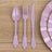 Purple plastic cutlery set: spoon, fork, and knife on wooden surface.