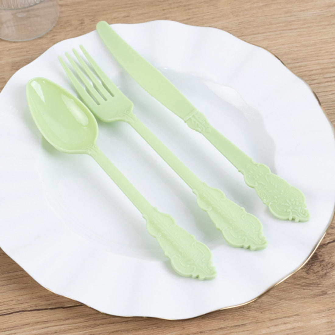 Pastel green cutlery set on a white plate.