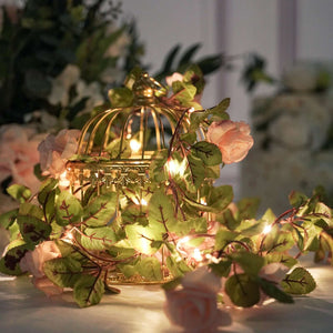 Decorative birdcage with fairy lights and floral accents.