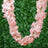 Pink floral garland on a green background.