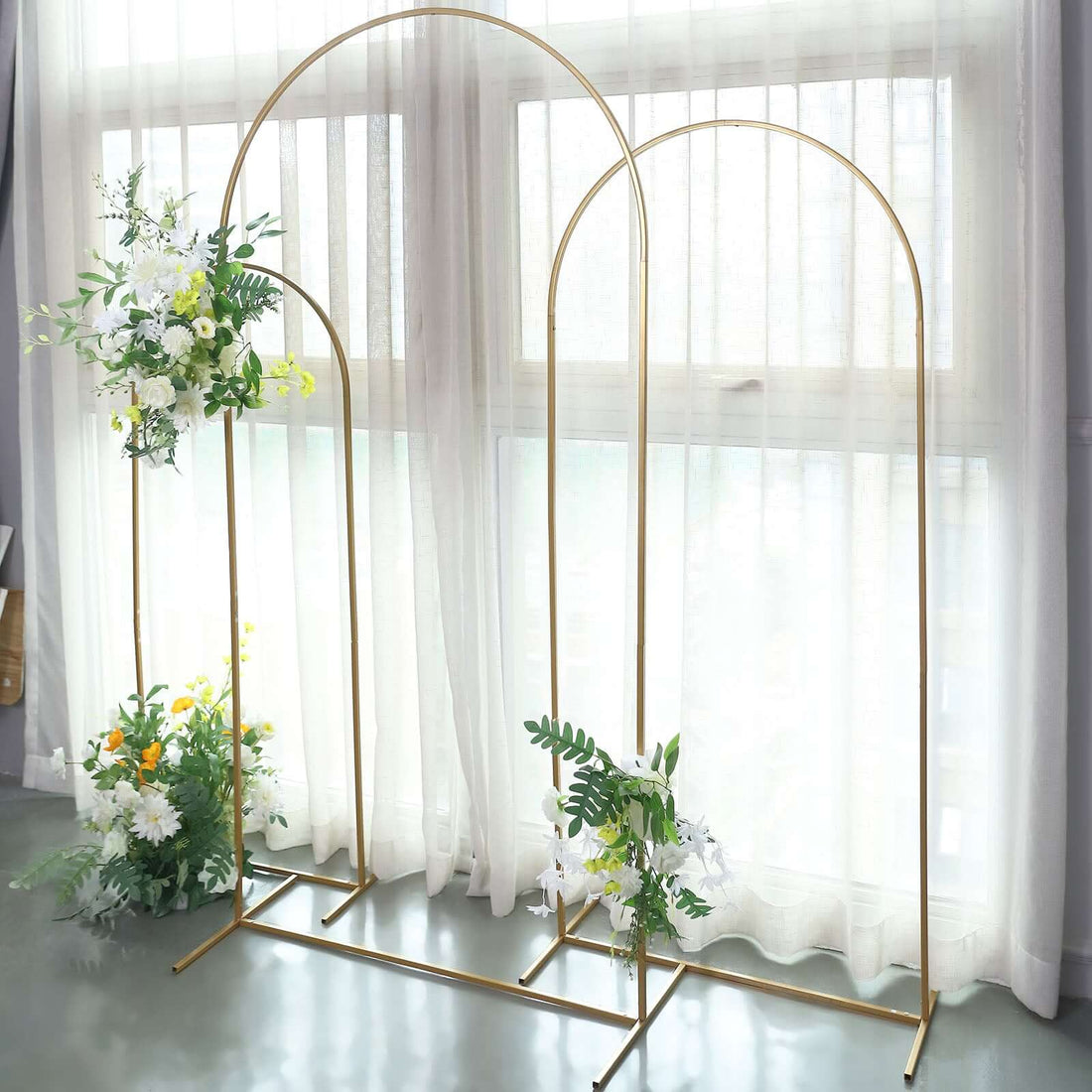 Gold arch backdrop with floral arrangements for events or photography.