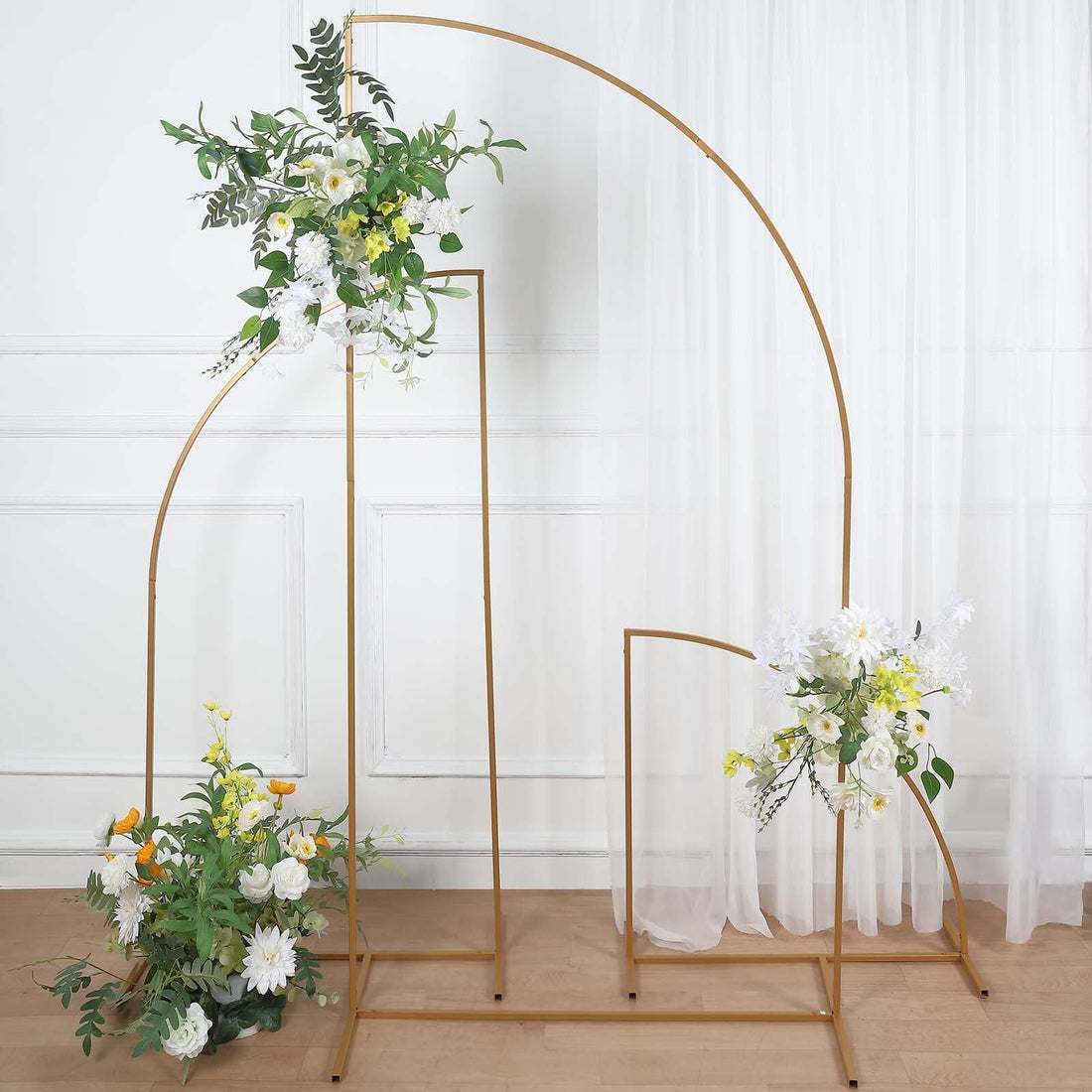 Decorative floral arch with gold frame and assorted flowers in a staged scene.