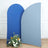 Two curved fabric backdrops in blue and gray with a floral arrangement at the base.