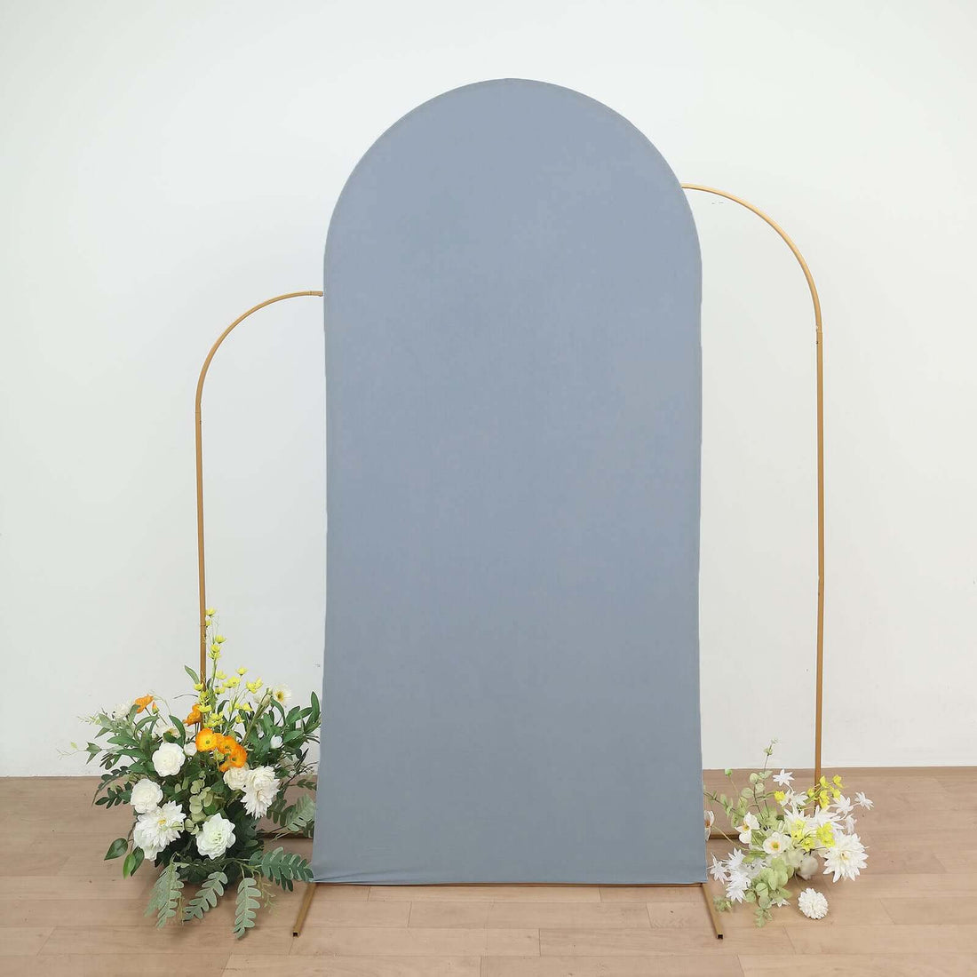 Gray backdrop with gold frame and floral arrangements at the base.