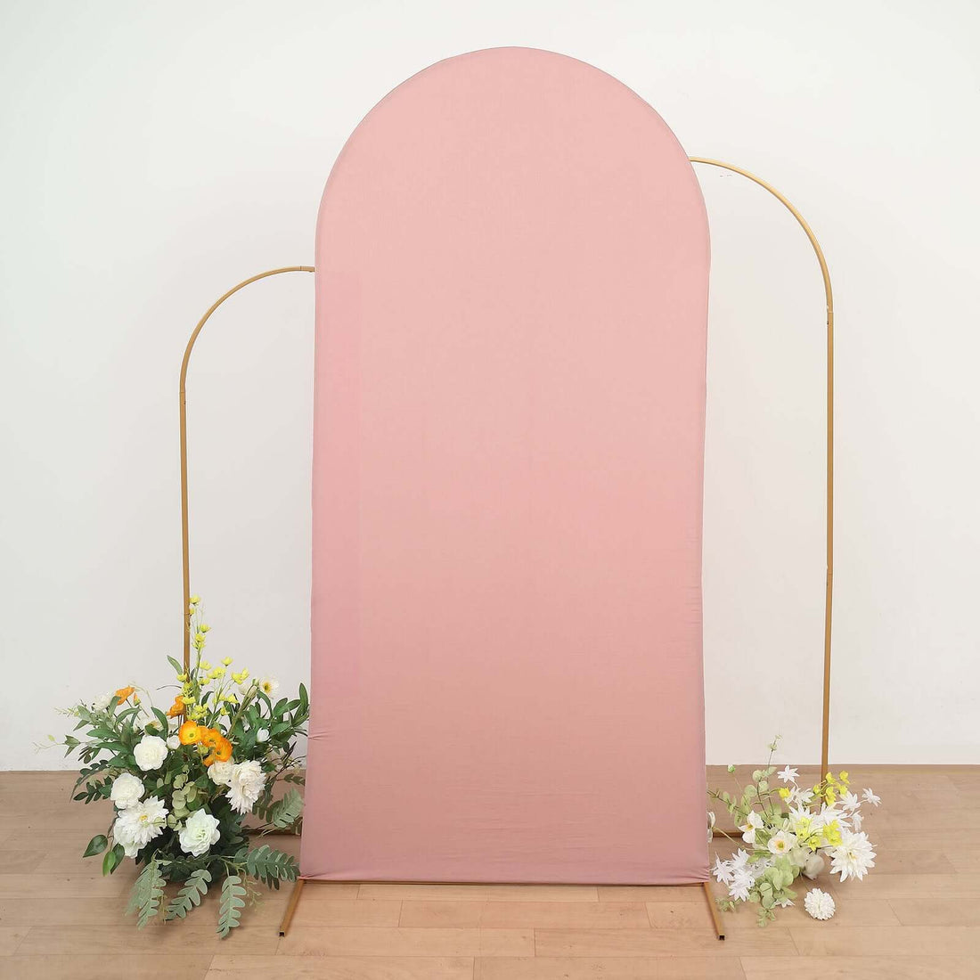 Pink backdrop with gold frame and floral arrangements