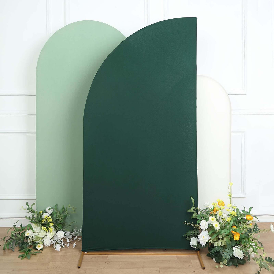 Green and white backdrop with floral arrangement in studio setting.
