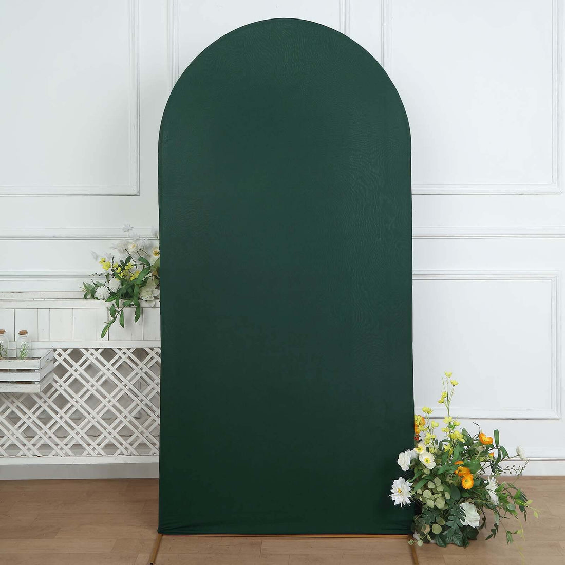 Green arch backdrop with floral arrangement at the base.